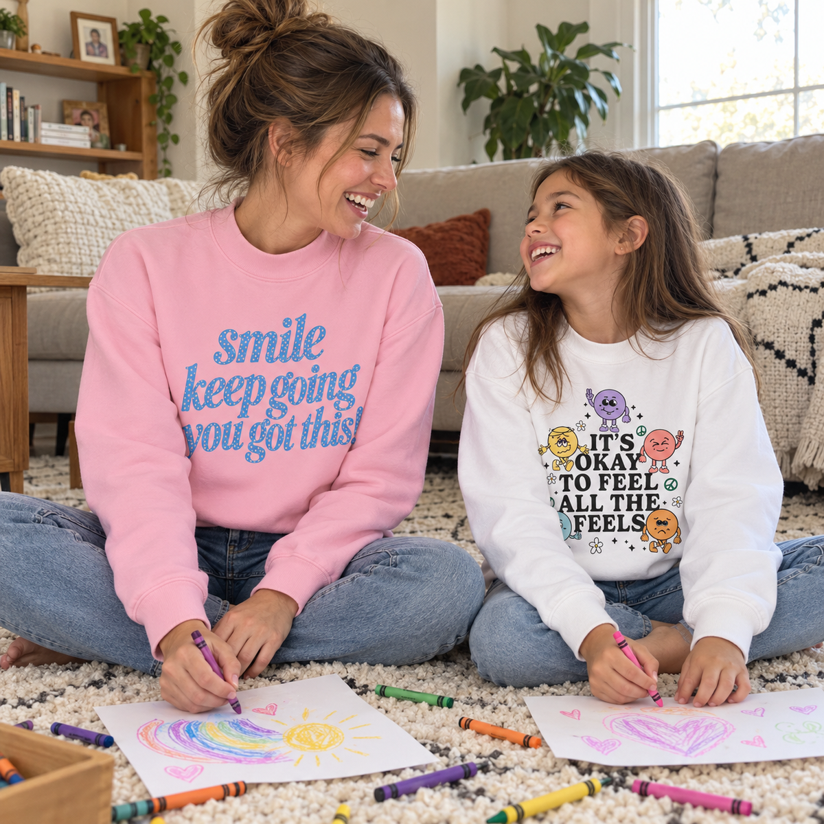 Mother and daughter wearing Smile clothing while drawing together at home